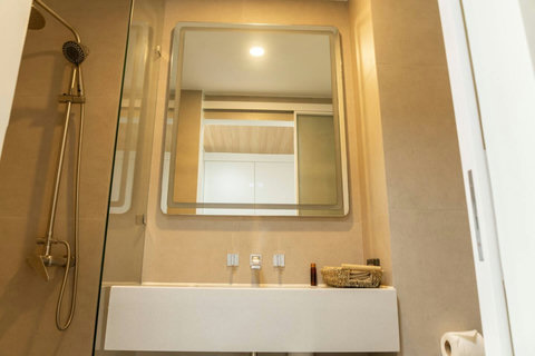 Bathroom vanity with large mirror and tidy storage basket for toiletries