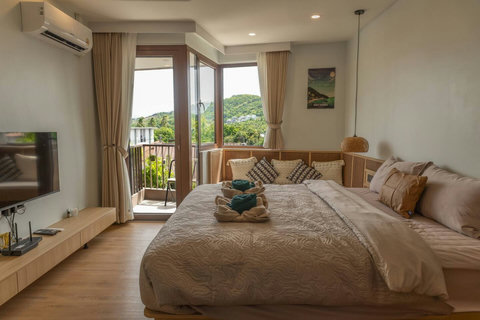 Evening view of the queen bed with Smart TV and balcony overlooking Chaweng
