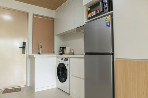 Well-equipped kitchenette with fridge, microwave and washing machine by the entrance