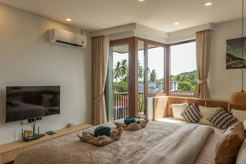 Corner windows frame swaying palm trees just steps from your Koh Samui balcony