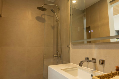 Modern en-suite bathroom with rain shower head and sleek glass screen
