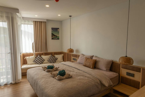 Cozy queen bed dressed with soft linens and warm evening lighting