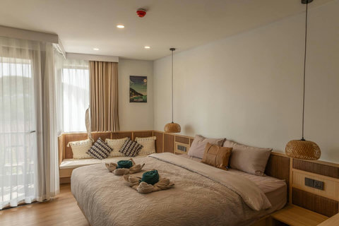 Relaxed bedroom corner with soft curtains and garden views from the balcony