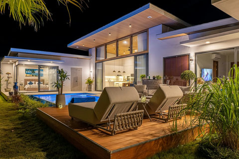 Evening ambiance by the pool, highlighting the open indoor-outdoor luxury concept.