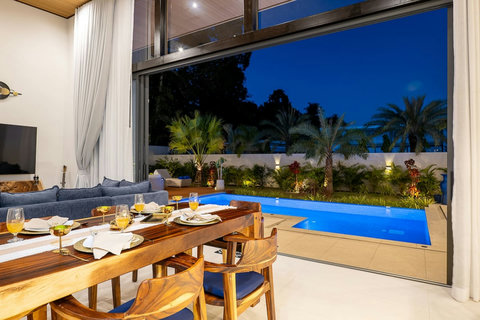 Spacious open-plan living room flowing directly to the illuminated pool area