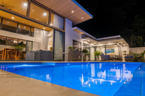 Stunning night view of the villa featuring warm architectural lighting and private garden.
