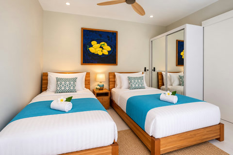Two comfortable beds in a bright, cool room with thoughtful design and plenty of storage.