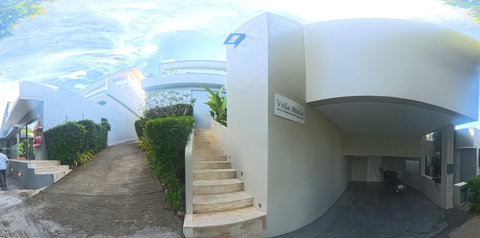 Villa Malai 's entrance with steps leading up to the villa and covered parking below