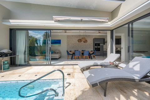 Lounge by the pool on comfortable chairs, surrounded by tropical gardens and calm.