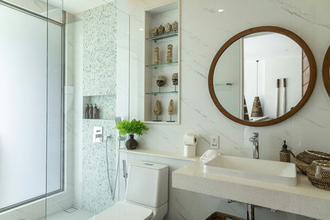 Bathroom with round mirror and rain shower