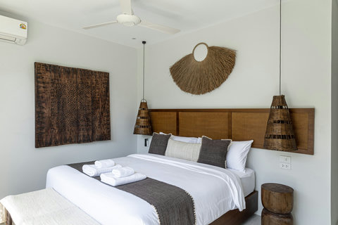 Bedroom with rattan headboard and pendant lamps