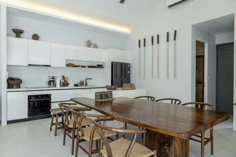 Kitchen with full size fridge and wooden dining table
