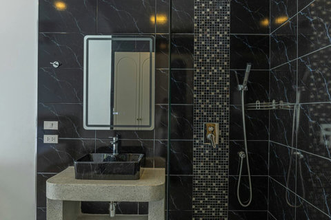 Modern bathroom with walk-in shower and stylish black marble finish.