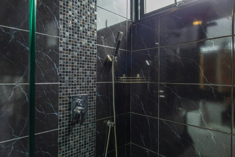 Modern walk-in shower with stylish black marble finish.