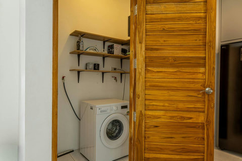 Private laundry area with washing machine for guest convenience.
