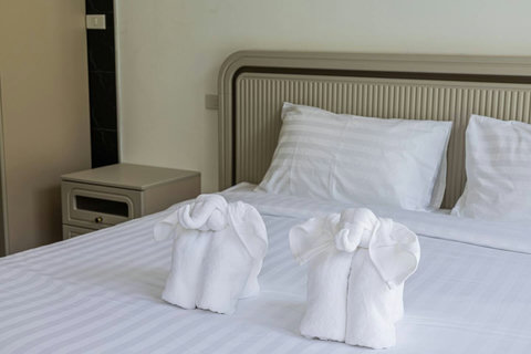 Welcoming bedroom with comfortable bedding and fresh towels ready for guests.