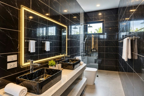 Modern bathroom with double sinks, large mirror and walk-in shower.