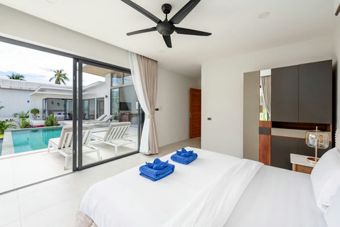 Poolside bedroom suite with glass doors, ceiling fan and modern furnishings - Green Garden Villa