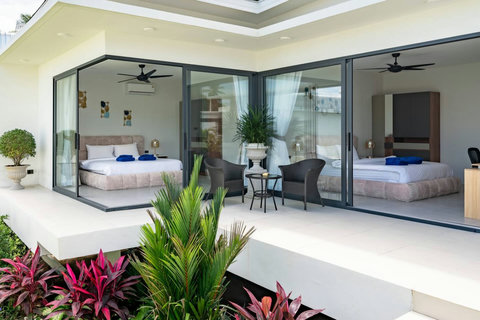 Covered terrace with glass doors to bedrooms, tropical plants and modern outdoor space - Green Garden Villa