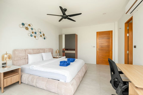 Comfortable bedroom with wood door, ceiling fan and modern furnishings - 3-bedroom Green Garden Villa