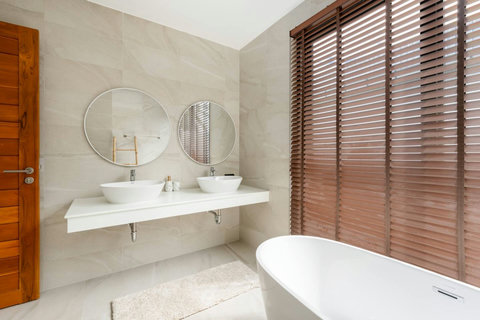 Luxurious ensuite bathroom with freestanding tub, double vanity and wood accents - spa-like Green Garden Villa