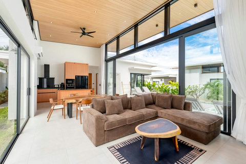 Spacious open-plan living room with comfortable sectional sofa, dining area and garden views - modern Green Garden Villa
