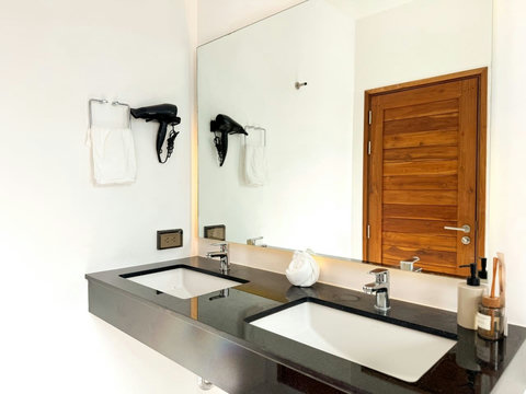 Spacious double vanity with modern finishes, large mirror and guest amenities.