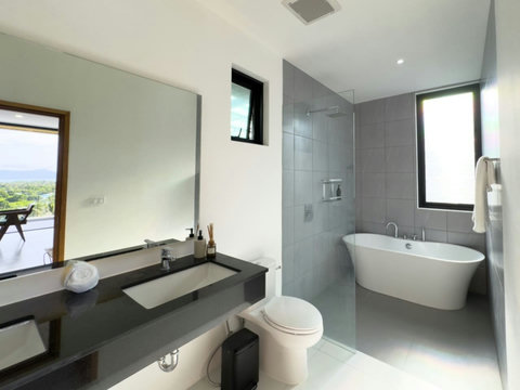 Bright modern bathroom with freestanding bathtub, walk-in shower and double vanity.
