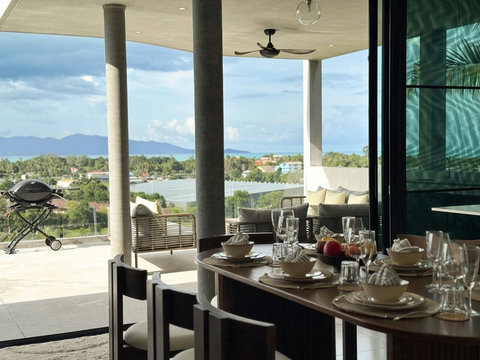 Indoor dining space opening onto the terrace, with Weber BBQ and beautiful hillside views.
