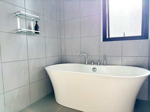 : Freestanding bathtub in a bright modern bathroom, perfect for a relaxing soak.