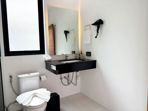 Clean modern bathroom with vanity, toilet and practical guest amenities.