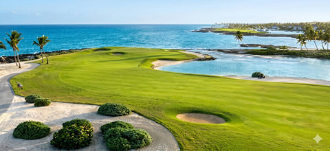 Oceanfront golf hole with palm-lined fairways and sparkling blue water views