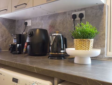 Kitchen with microwave, kettle, washing machine, dryer, toaster, air fryer, crockery, cutlery, wine glasses, cooking pans, utensils, coffee maker