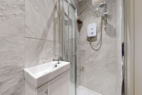 Step into a sleek, modern bathroom with high-end fixtures, fresh towels, and premium toiletries, including shower gel, shampoo, conditioner, and soap, for a comfortable, refreshing experience. A hair dryer is provided for your convenience.