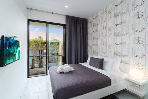 3rd bedroom with queen sized bed, desk, closet and balcony outside.