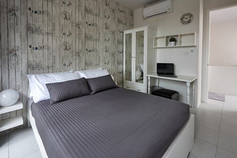 3rd bedroom with queen sized bed, desk, closet and balcony outside.