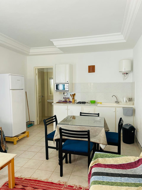 Espace repas lumineux avec table et chaises confortables, parfait pour savourer vos plats faits maison.