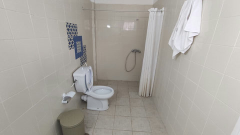 Salle d’eau moderne avec douche à l’italienne, serviettes propres et sèche-cheveux. Espace lumineux et fonctionnel pour un confort optimal.