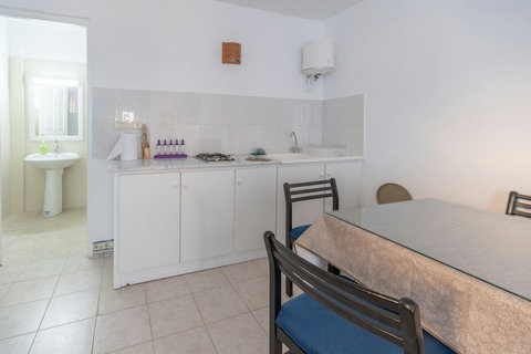 Kitchenette moderne équipée : réfrigérateur, plaques, micro-ondes et vaisselle. Idéale pour préparer vos repas et profiter d’un séjour autonome à Djerba.