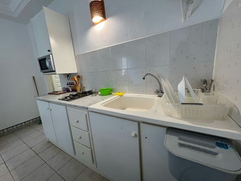 Kitchenette moderne équipée : réfrigérateur, plaques, micro-ondes et vaisselle. Idéale pour préparer vos repas et profiter d’un séjour autonome à Djerba.