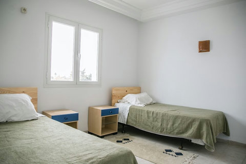 Chambre climatisée avec lit confortable, linge de qualité et espace de rangement. Ambiance paisible et déco inspirée de Djerba pour un repos total.