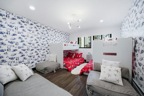 Fun colorful bunk room with built-in beds, comfy lounge seating & en suite bathroom.