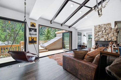 Bright mountain living room with deck access, swing chair and sweeping mountain views