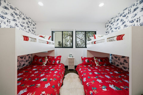 Cheerful bunk room with cozy beds, playful decor, and space for the whole crew.  These are holiday sheets but the decor is fun yearround.