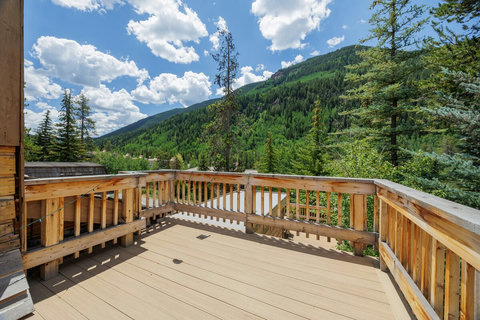 Spacious mountain-view deck surrounded by trees and fresh alpine air