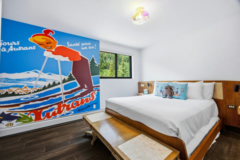 Bright secondoary bedroom suite with mountain views and a striking vintage ski mural and a smart tv