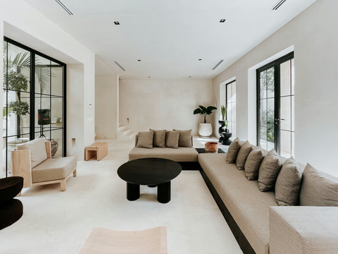 Bright, minimalist living room with plush seating, natural light, and a calm, modern atmosphere
