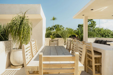 Relaxed outdoor dining space surrounded by tropical greenery and blue skies