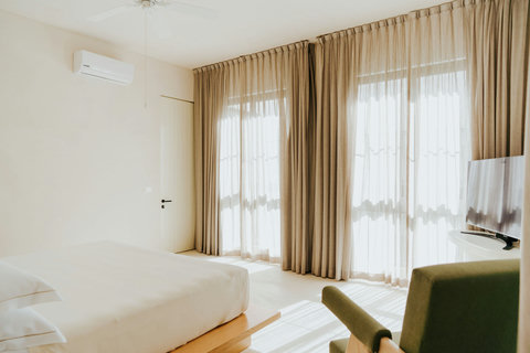 Cozy bedroom with natural light, ceiling fan, and accent chair