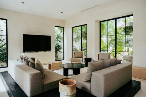 Sleek modern living room featuring a Smart TV and floor-to-ceiling garden views